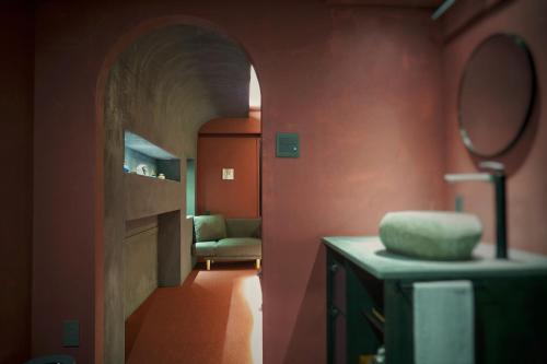 a bathroom with a hallway with a mirror and a chair at MATSUMOTO CASTLE hostel in Matsumoto