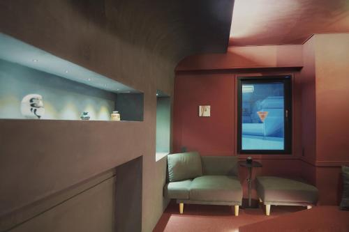a waiting room with a chair and a window at MATSUMOTO CASTLE hostel in Matsumoto