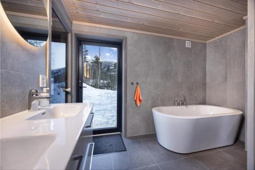 a bathroom with two sinks and a tub and a window at Lakelodge 10p in Vradal