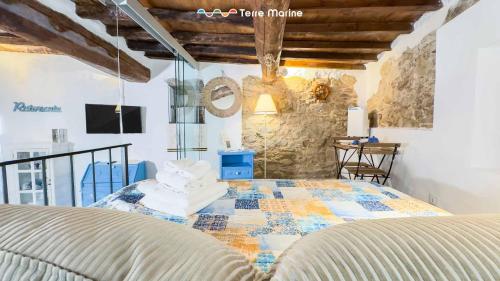 a bedroom with a bed and a stone wall at Rio Alba Blue, Terre Marine in Riomaggiore
