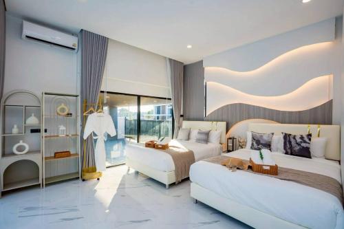 a large bedroom with two beds and a couch at Cloud Pool Villa Pattaya in Na Jomtien