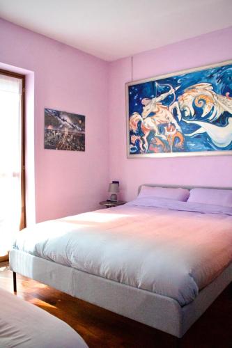 a bedroom with a bed with a painting on the wall at Tra le Alpi - Holiday House in Tresivio