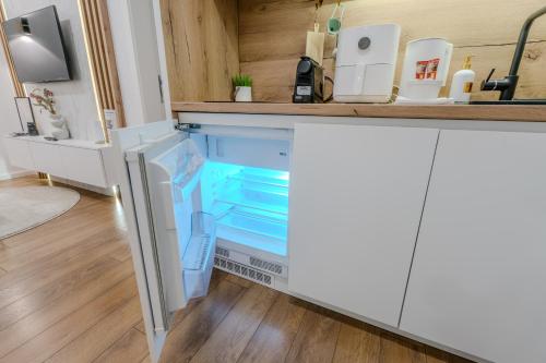 a refrigerator with its door open in a kitchen at Mona Luxury Apartments - Free Garage Parking in Sarajevo