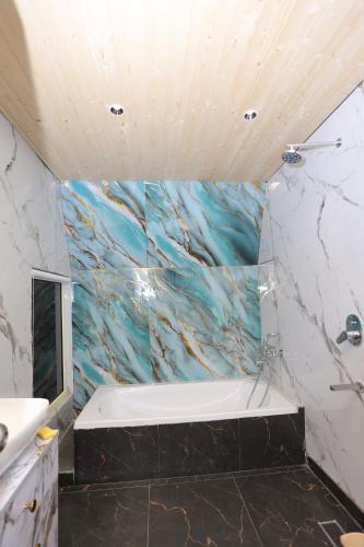 a bathroom with a sink and a bath tub at Alpine Vista Wellness & Resort in Gupta Kāshi