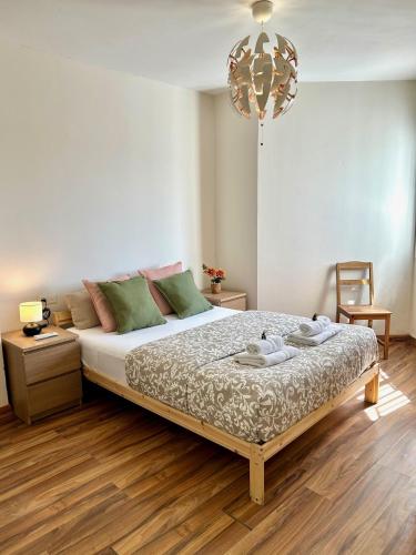 a bedroom with a bed and a chandelier at GATU City Puerto Preferente mayores 21 años y familias in El Puerto de Santa María