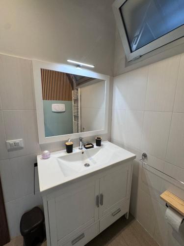 a bathroom with a white sink and a mirror at Cristina Home in Taranto