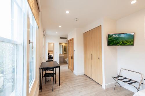a living room with a table and a desk at NOX Kensington in London