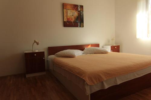 a bedroom with a bed and a lamp on a table at Apartments Daidzic by El-Pi Tours in Njivice