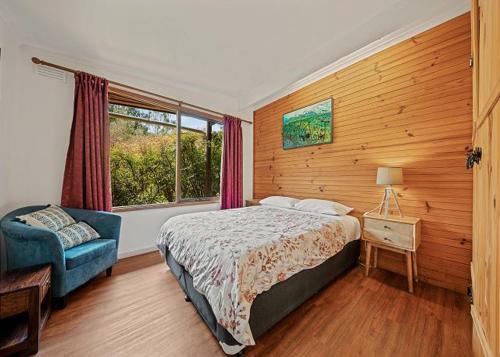 a bedroom with a bed and a chair and a window at Stonehaven in Freeburgh