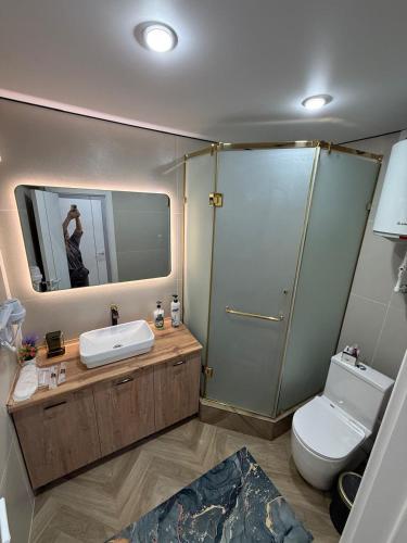 a bathroom with a sink and a toilet and a mirror at Korkyt in Qyzylorda