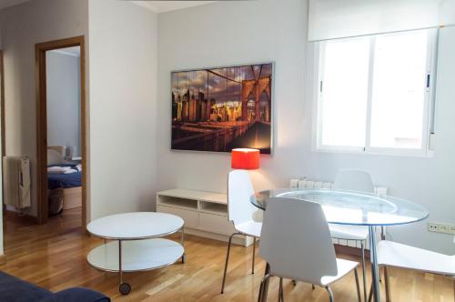 comedor con mesa y sillas blancas en For You Rentals reina sofia apartment DF21, en Madrid