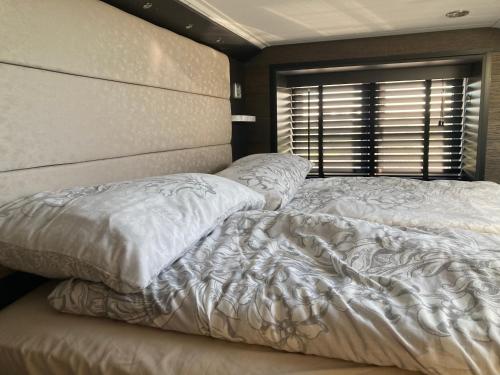 a bedroom with two white beds and a window at Chapel Fields Holiday Park in Chapel Saint Leonards