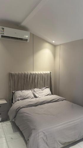 a bed in a white room with avertisement at شاليهات وقت الفرح in Riyadh