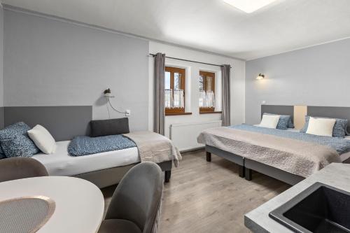 a hotel room with two beds and a table at Penzion Na Chalupě in Polička