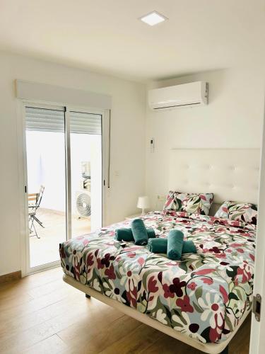 a bedroom with a bed with a floral comforter at Casa Privada Benidorm Centro in Benidorm