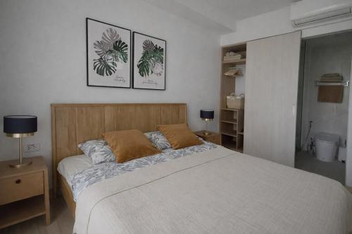 a bedroom with a bed and two pictures on the wall at Skypark Celeste with stunning golf course view in Laguna Phuket