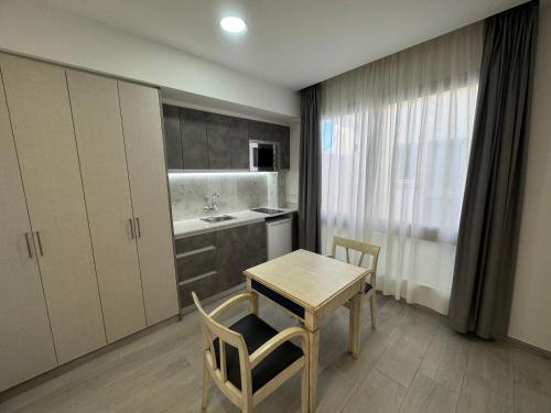 a kitchen with a table and chairs and a table and a sink at Apartamentos Colón Playa in Las Palmas de Gran Canaria