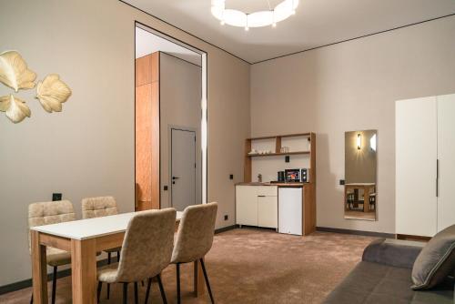 a living room with a dining room table and chairs at Nord Karakol Hotel in Karakol