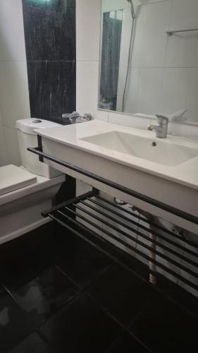a bathroom with a white sink and a mirror at Pearl City Resort in Tissamaharama