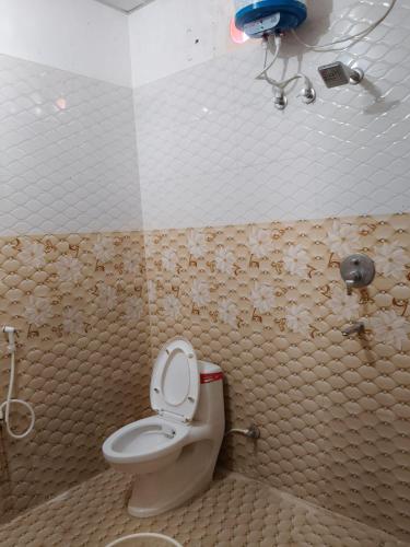 a bathroom with a toilet in a room with tiles at Ayodhya Stay in Ayodhya