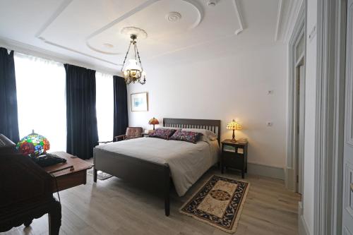 a bedroom with a bed and a table and a piano at Santiago de Caminha Boutique Hostel & Suites in Caminha