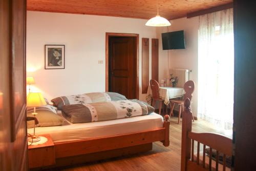 a bedroom with a bed and a desk and a table at mösslerhof in Aldino