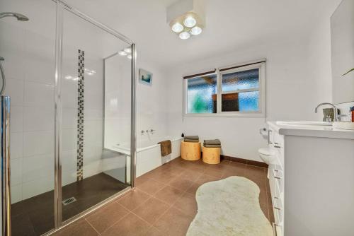 a bathroom with a shower and a toilet and a sink at Three Pines on Grange in Porepunkah