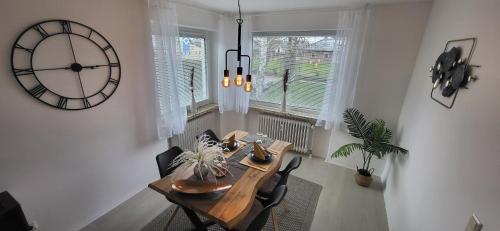 a dining room with a table and a large clock at Birkenhain in Geltorf