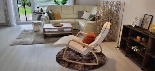 a living room with a chair and a couch at Birkenhain in Geltorf
