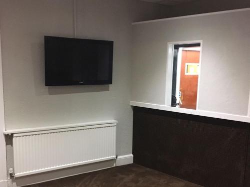 a living room with a flat screen tv on the wall at Richmond House Hotel in Southport