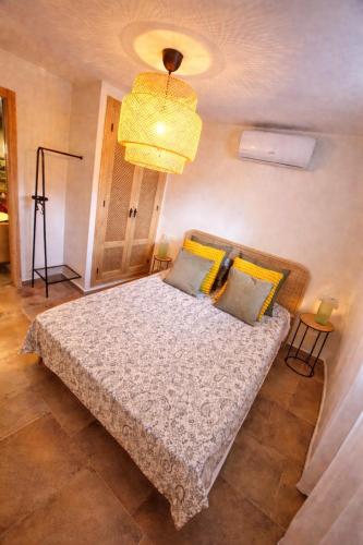 a bedroom with a bed and a chandelier at Olé Toledo in Cómpeta