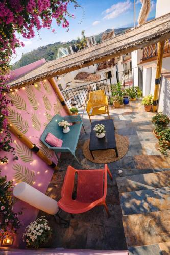 a patio with chairs and tables on a balcony at Olé Toledo in Cómpeta