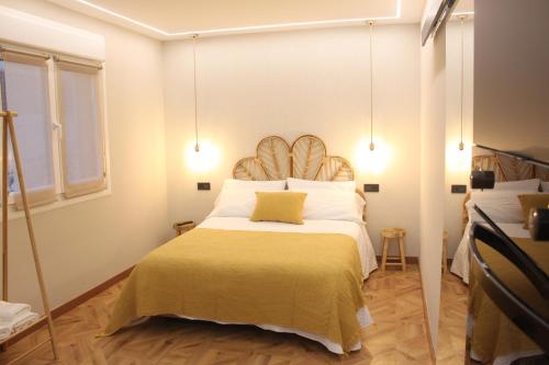 a bedroom with a large bed with a yellow pillow at Chouciña Apartments in Sanxenxo