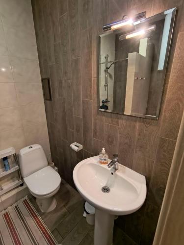 a bathroom with a white sink and a toilet at Orange Guest Rooms in Odesa