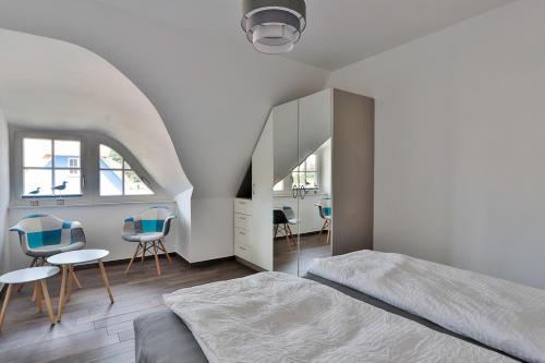 a bedroom with a bed and chairs and a staircase at FH Wiesenkieker in Güstow