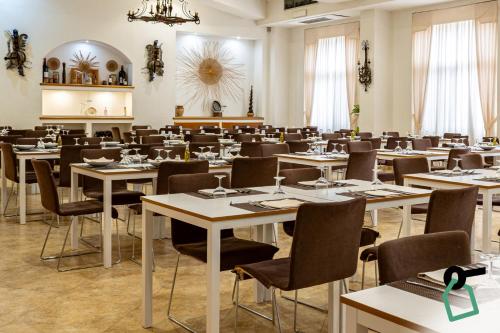 a dining room with tables and chairs and a room filled with at Hotiday Gallipoli Centro in Gallipoli