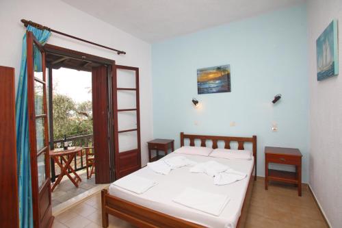 a bedroom with a bed and a balcony at Kastri in Panormos Skopelos