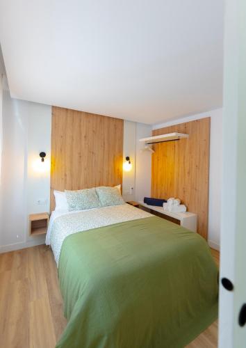 a bedroom with a green bed in a room at Lar de Sefa 15 in Redondela