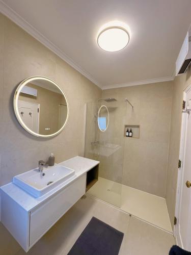 a bathroom with a sink and a mirror and a shower at Bay Golf House in Cascais