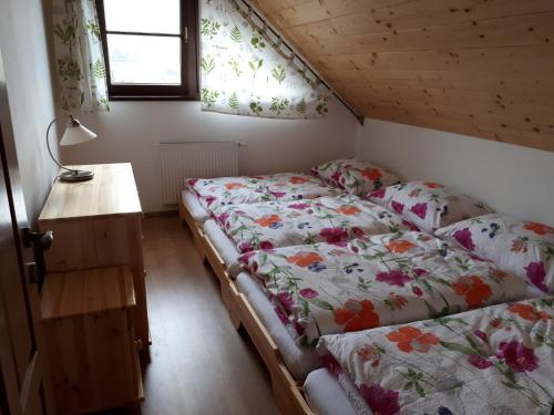 a bedroom with two beds and a desk and windows at Chalupa Šalalandia in Zázrivá