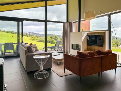 a living room with a couch and a tv and a table at Villas Winterberg in Winterberg