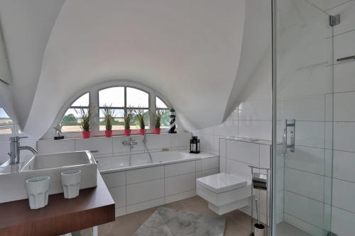 a white bathroom with a sink and a shower at FH Seeschwalbe in Niendorf