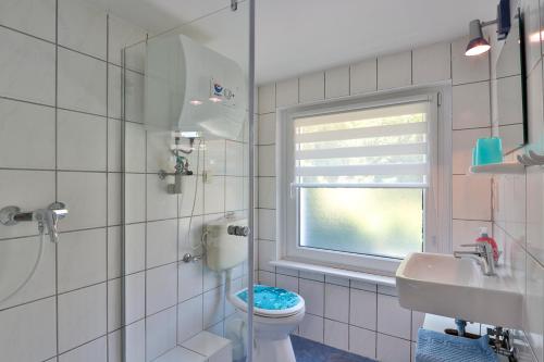 a bathroom with a toilet and a window at Bungalow Wolfgang in Kühlungsborn