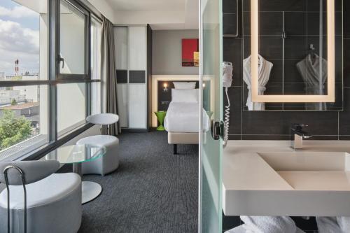 a bathroom with a sink and a mirror at Hôtel Restaurant Athena Spa in Strasbourg