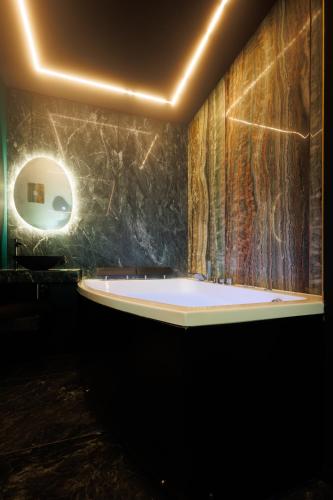 a bathroom with a large tub in a room at Suite Dark Luxe avec Écran géant de cinéma et jacuzzi in Clary