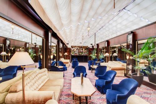 a lobby with couches and chairs and plants at Grand Hotel de l'Opera - BW Premier Collection in Toulouse