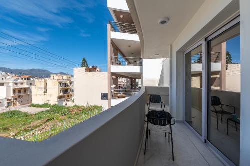 a balcony with two chairs and a view of the city at Kamara View Apt 2 in Agios Nikolaos