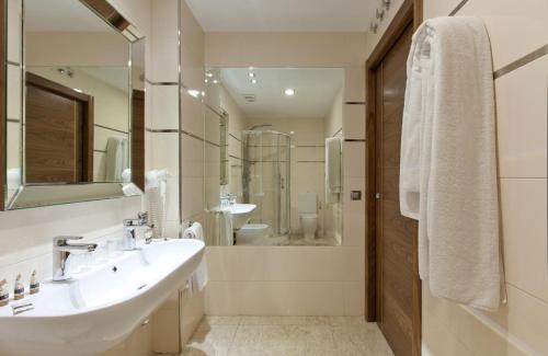 a bathroom with a sink and a mirror at Gran Hotel Corona Sol in Salamanca