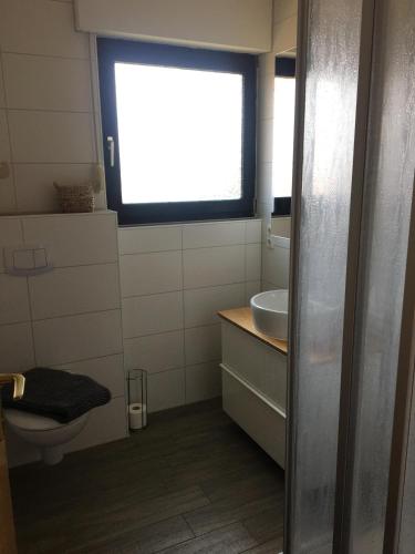 a bathroom with a toilet and a sink and a window at Ferienhaus Familie Lehmann in Borkum