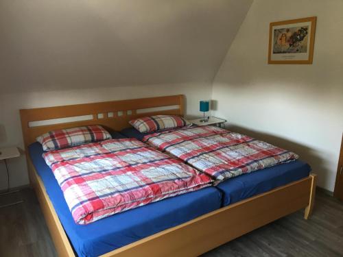a bedroom with a bed with a blue comforter and two pillows at Ferienhaus Familie Lehmann in Borkum